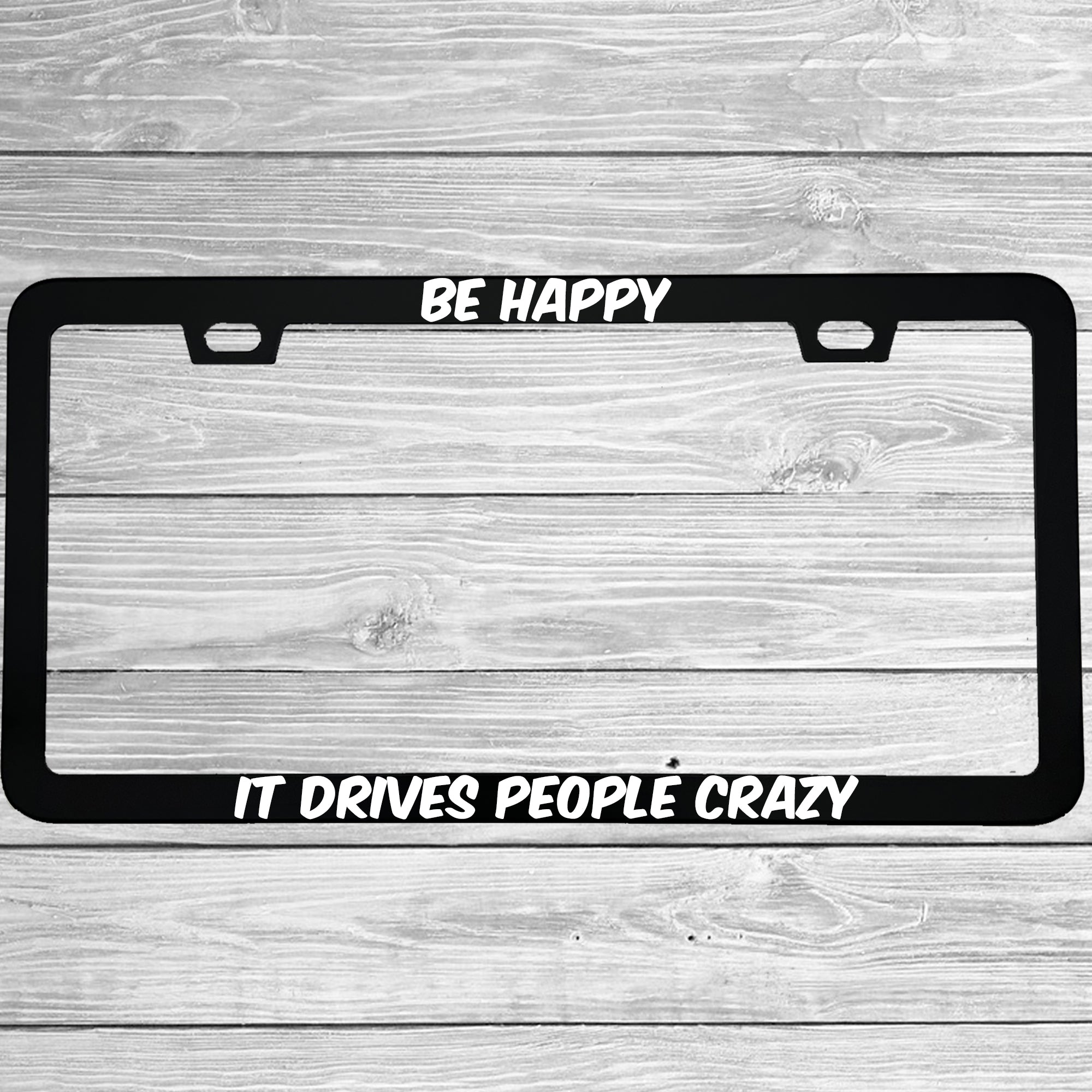 Close-up of "Be Happy It Drives People Crazy" license plate frame showing fade-proof print quality
