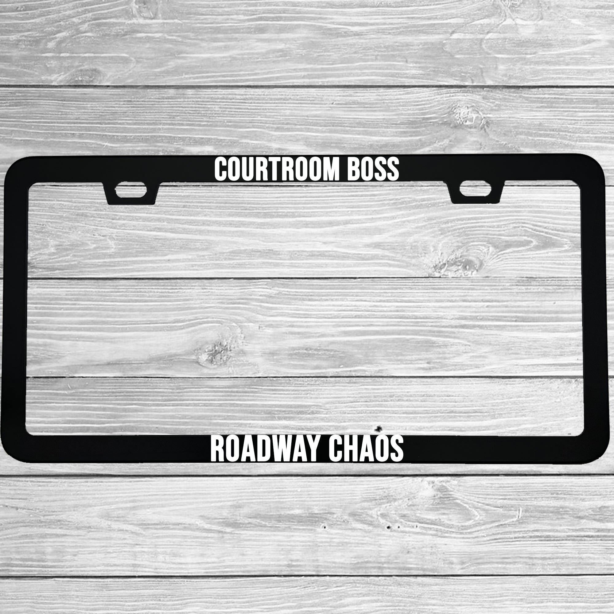 Close-up of "Courtroom Boss, Roadway Chaos" license plate frame showing fade-proof print quality