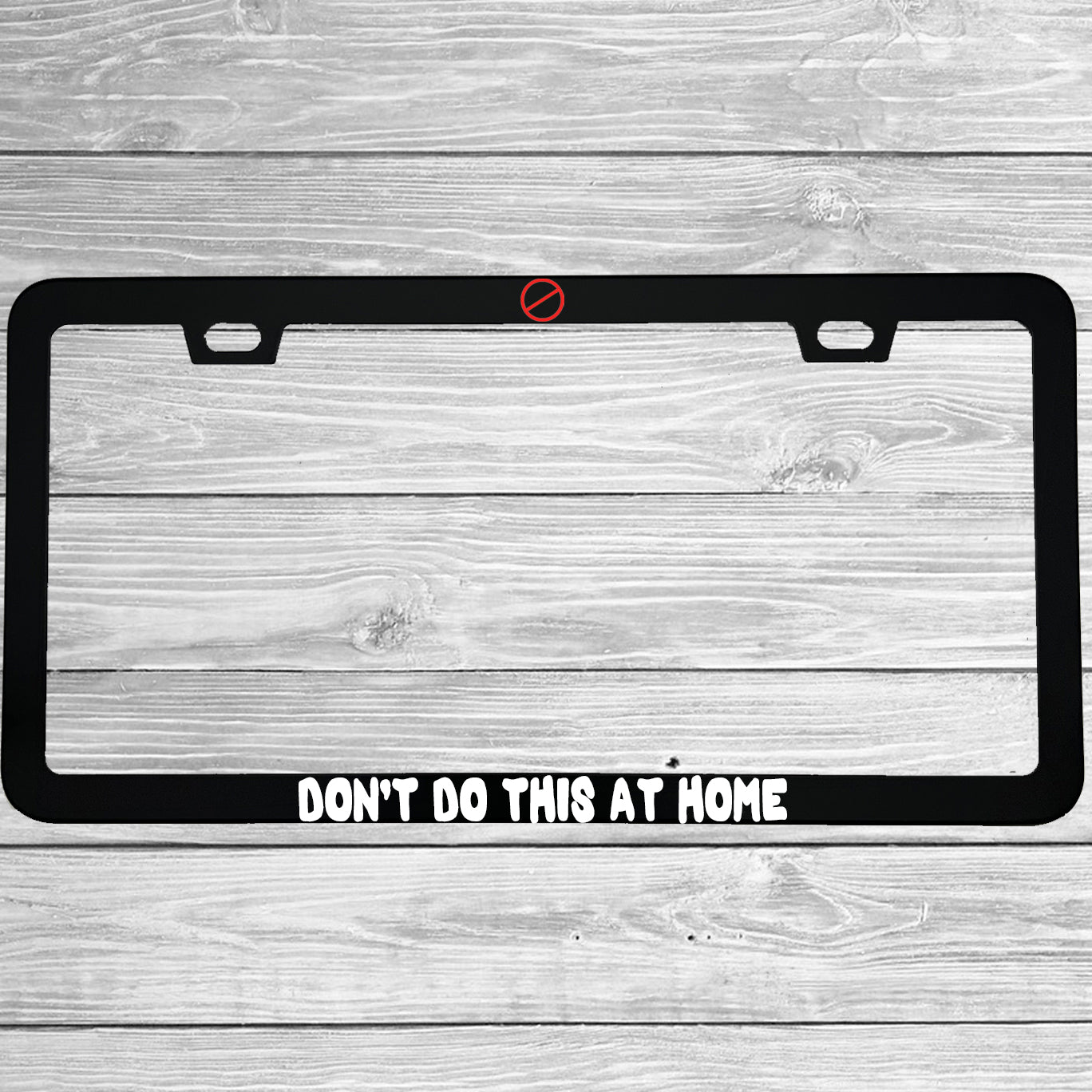 Close-up of "Don't Do This At Home" license plate frame showing fade-proof print quality