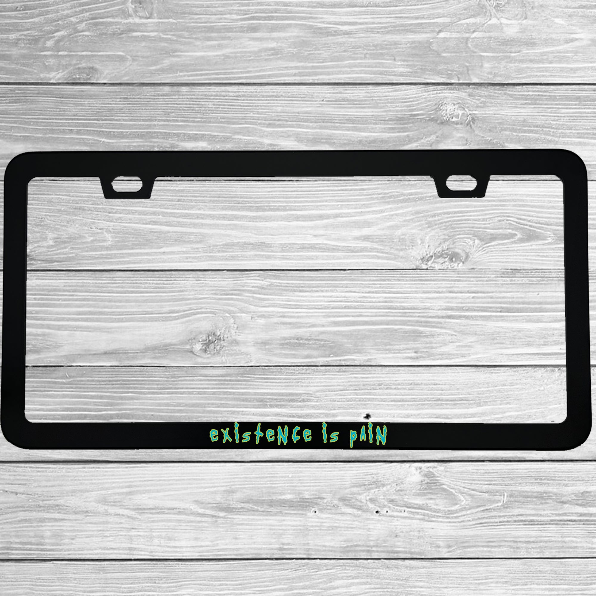 Close-up of "Existence is Pain" license plate frame showing fade-proof print quality