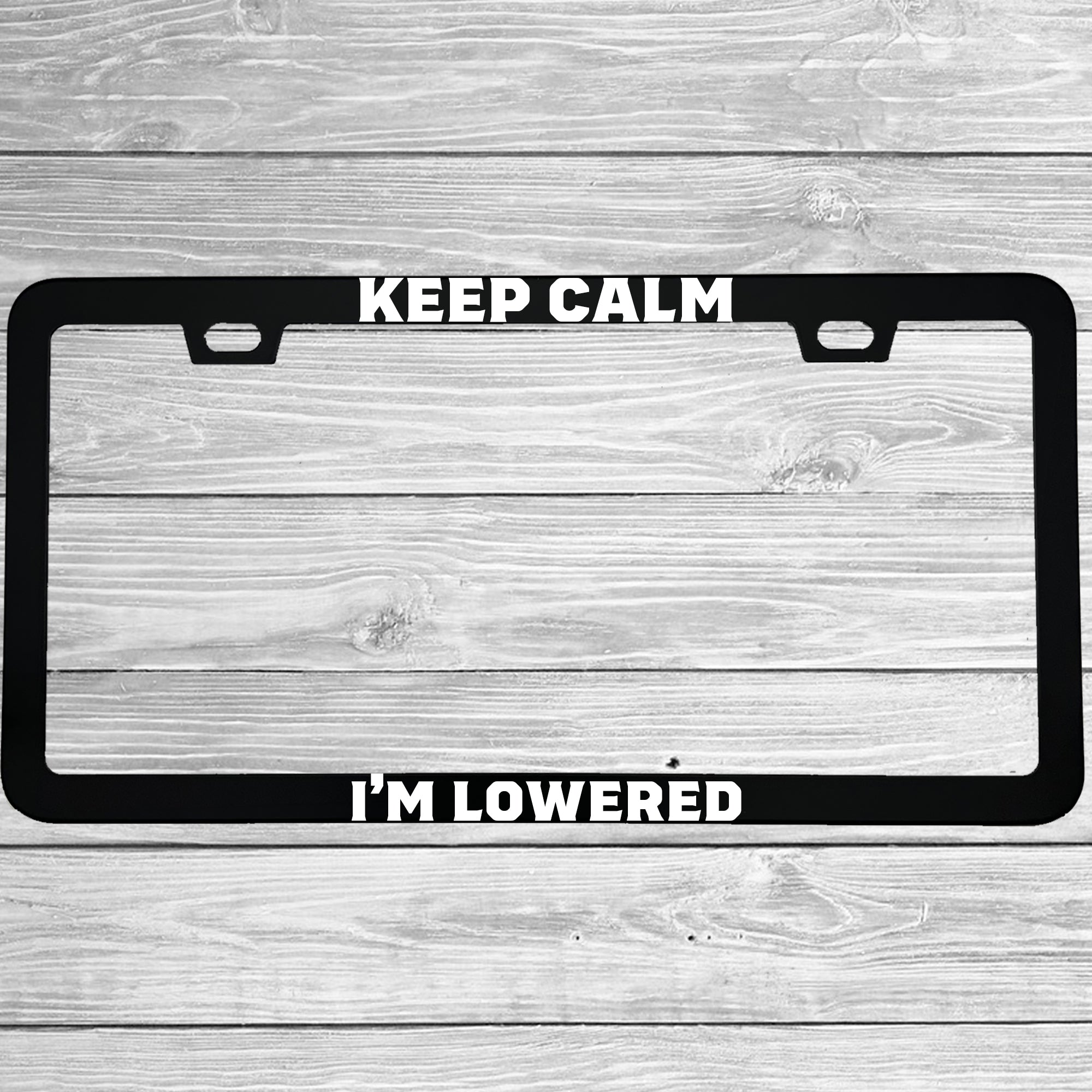 Close-up of "Keep Calm I'm Lowered" license plate frame showing fade-proof print quality