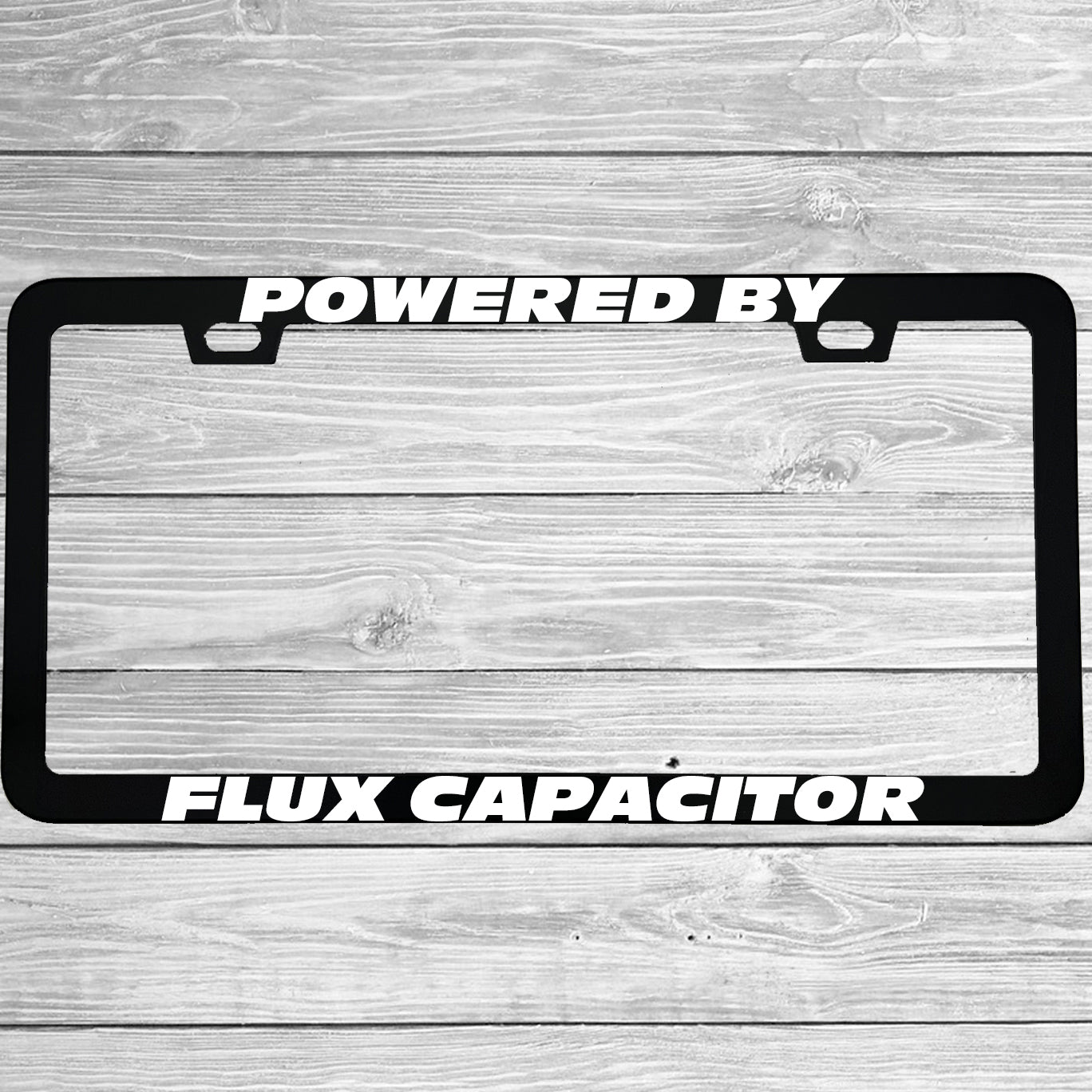 Close-up of "Powered By Flux Capacitor" license plate frame showing fade-proof print quality