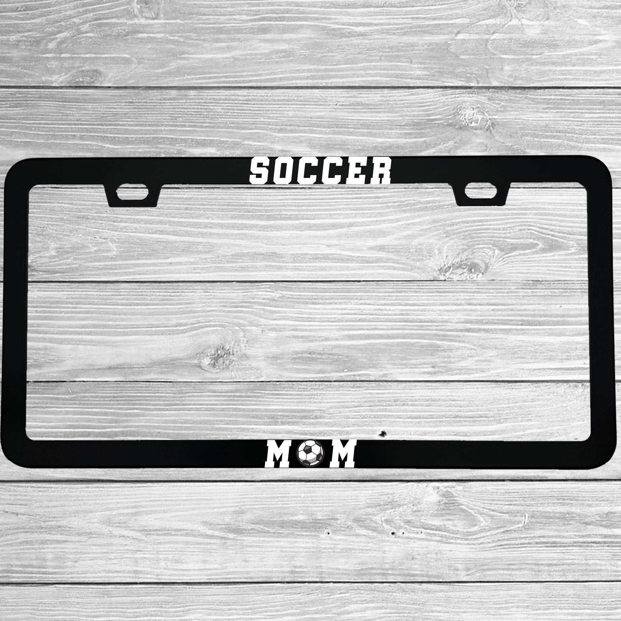 Close-up of "Soccer Mom" license plate frame showing fade-proof print quality