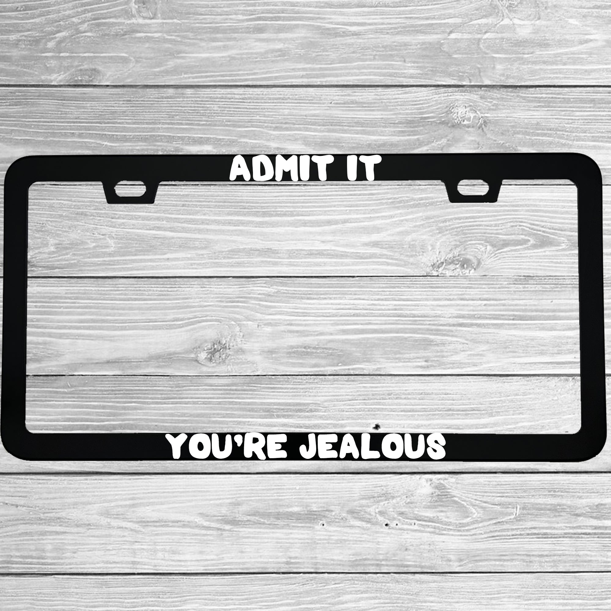Close-up of "Admit It You're Jealous" license plate frame showing fade-proof print quality