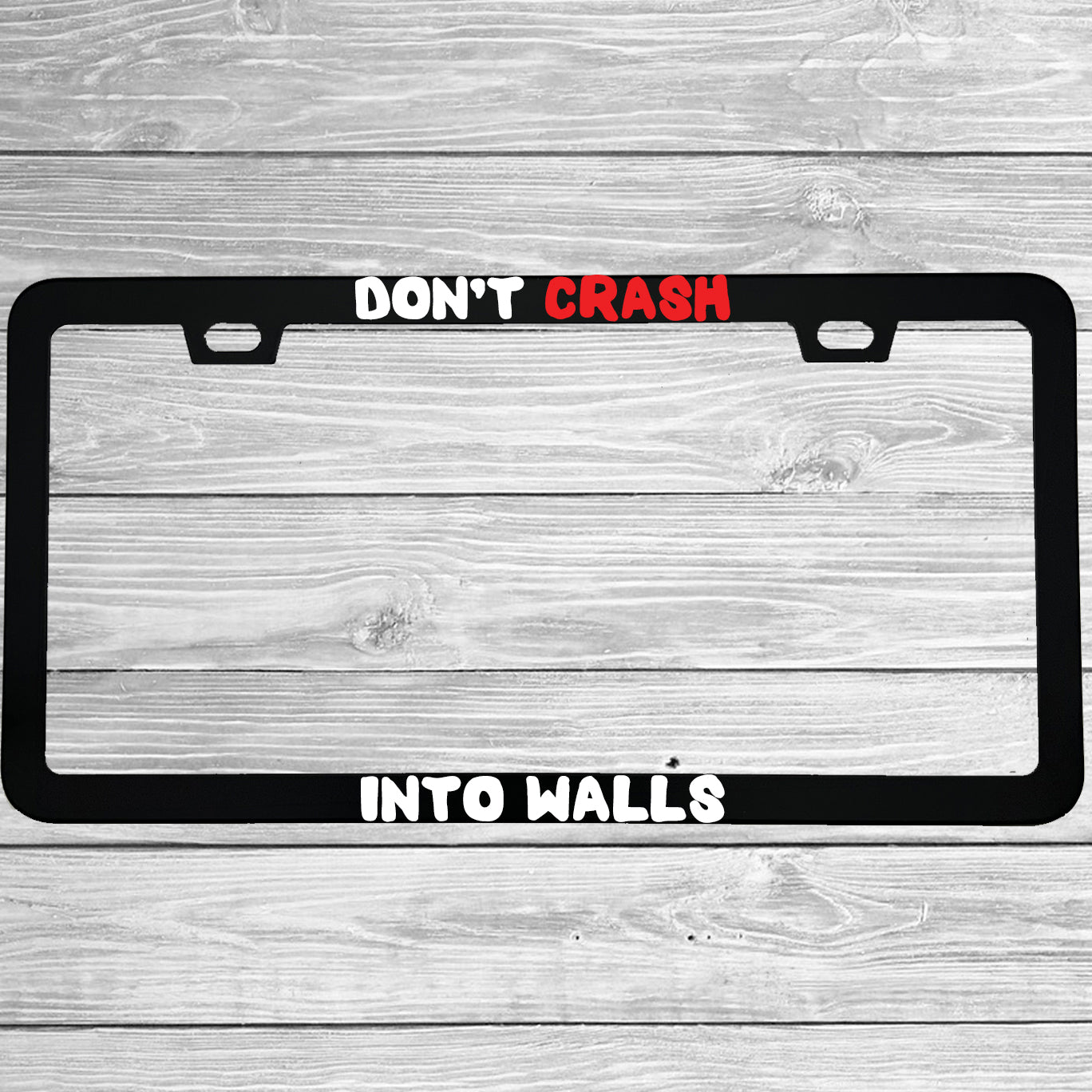 Close-up of "Don't Crash Into Walls" license plate frame showing fade-proof print quality