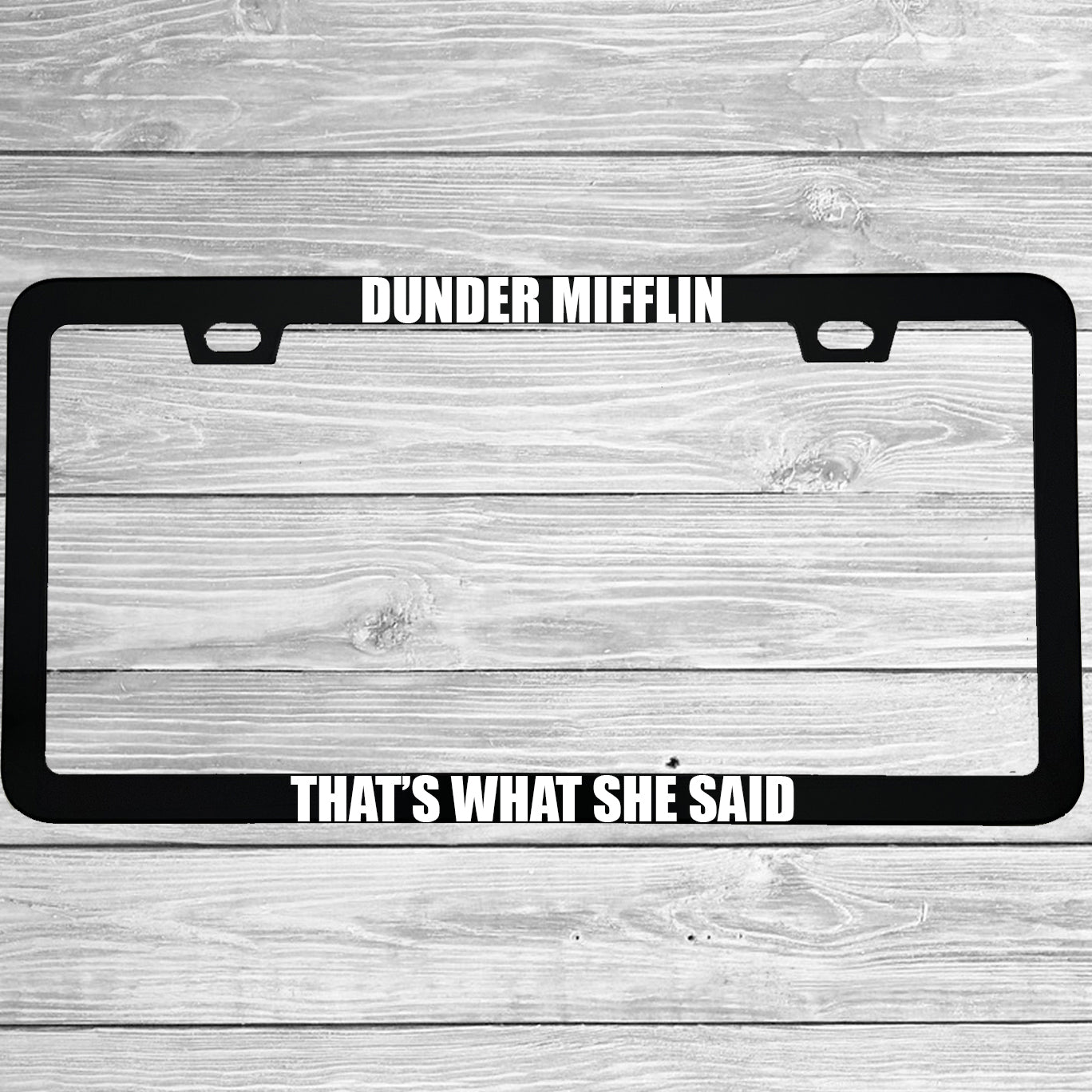 Close-up of "Dunder Mifflin That's What She Said" license plate frame showing fade-proof print quality