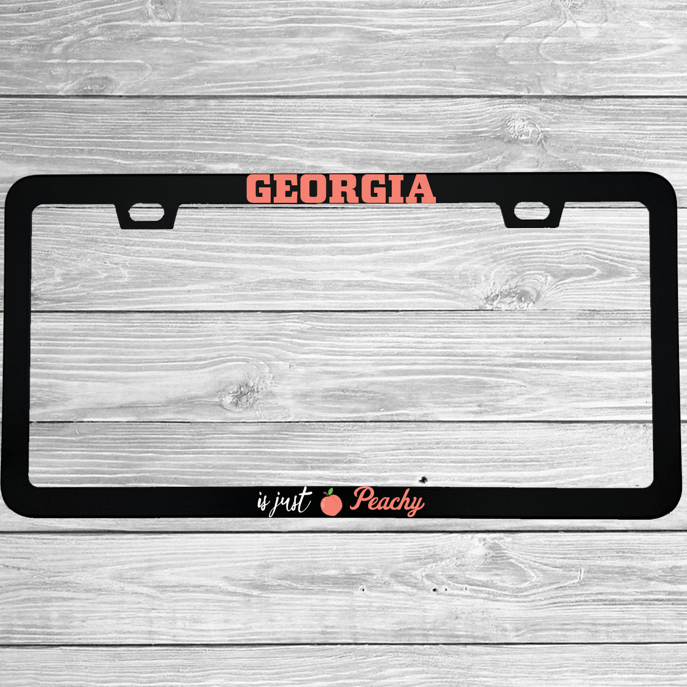 Close-up of "Georgia Is Just Peachy" license plate frame showing fade-proof print quality