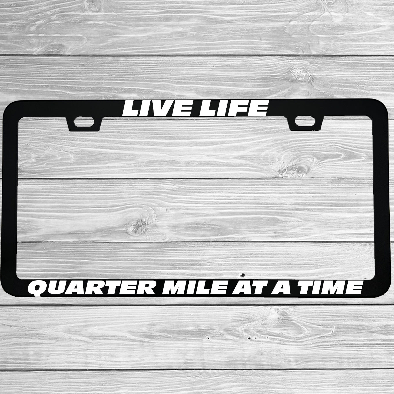 Close-up of "Live Life Quarter Mile At A Time" license plate frame showing fade-proof print quality