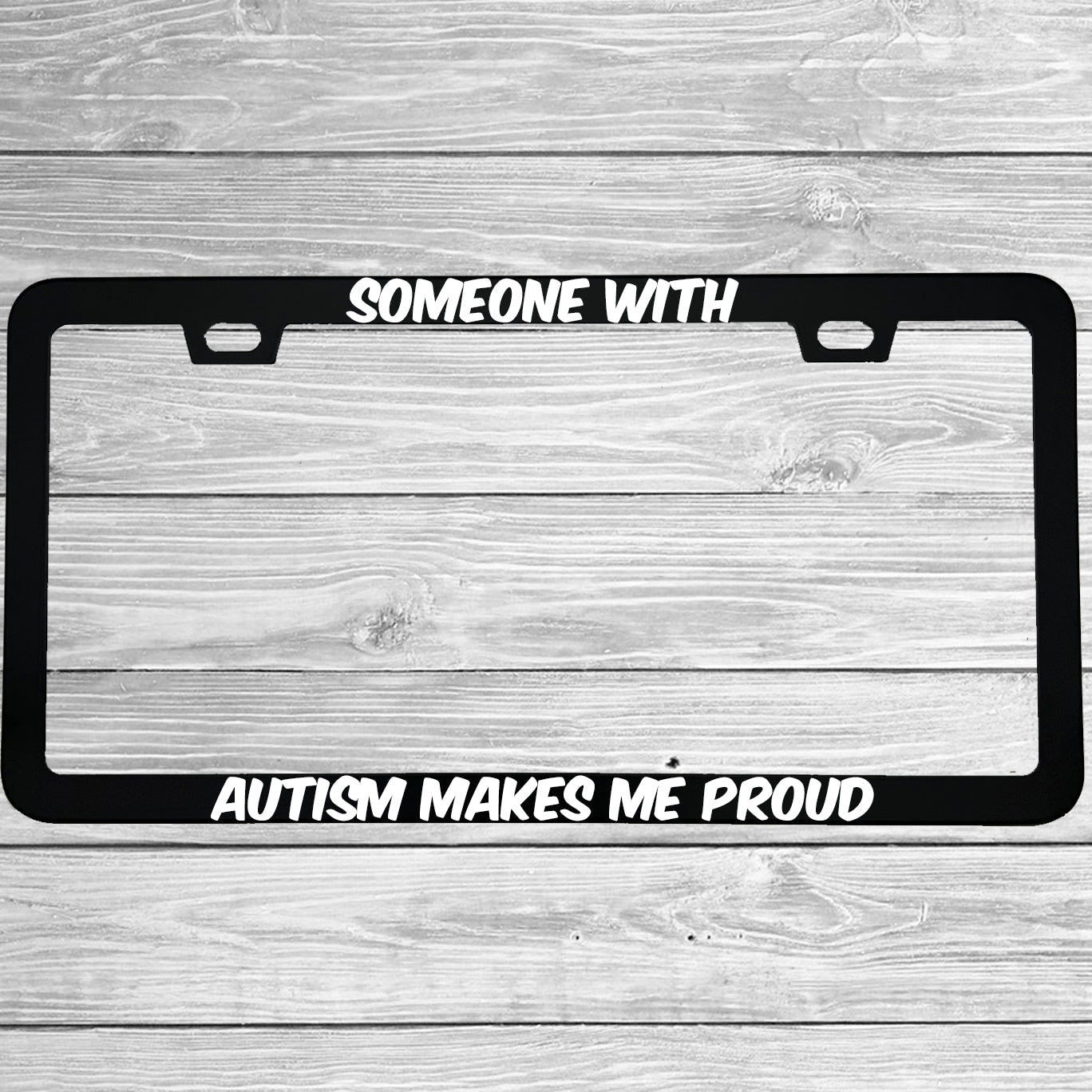 Close-up of "Someone With Autism Makes Me Proud" license plate frame showing fade-proof print quality
