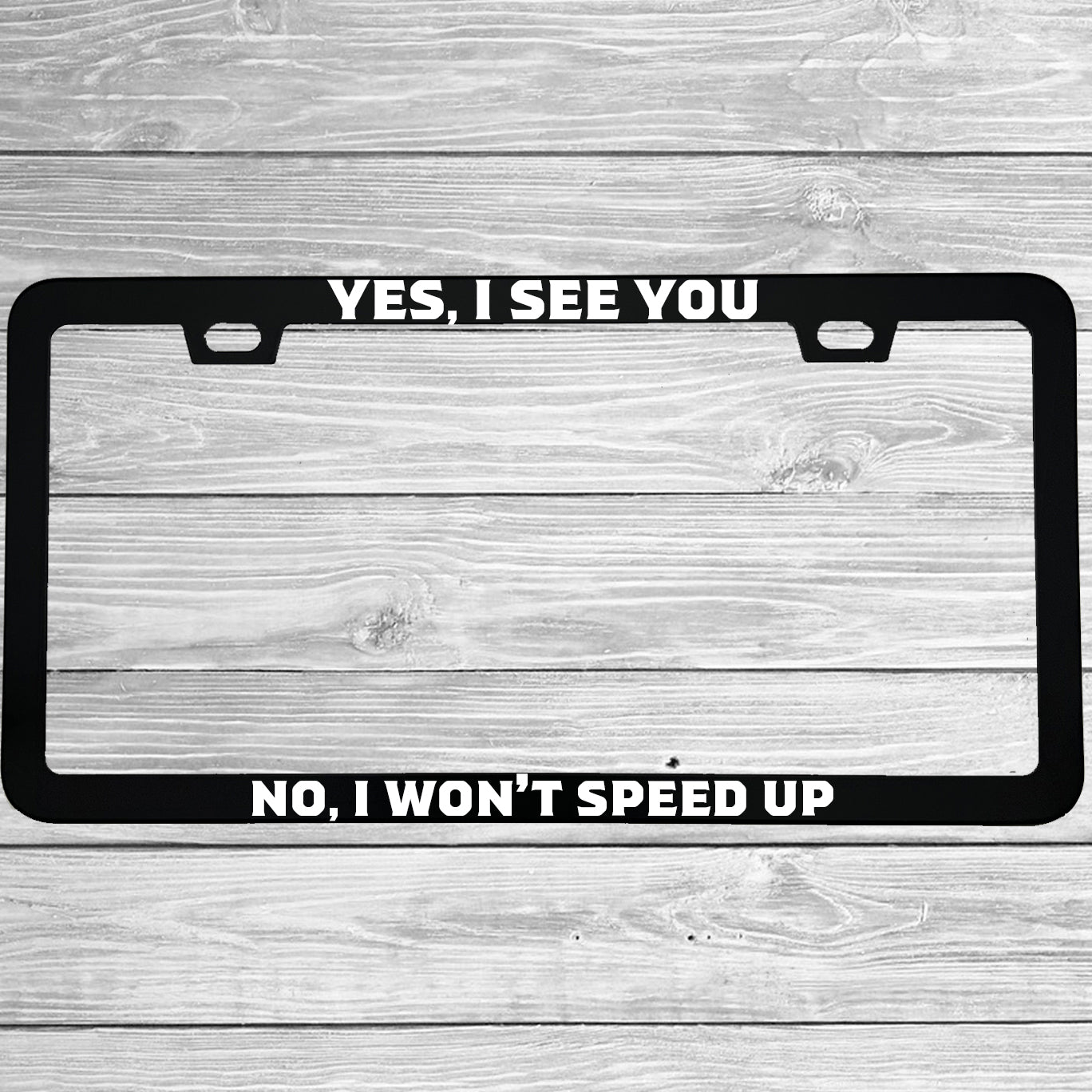 Close-up of "Yes I See You No I Won't Speed Up" license plate frame showing fade-proof print quality