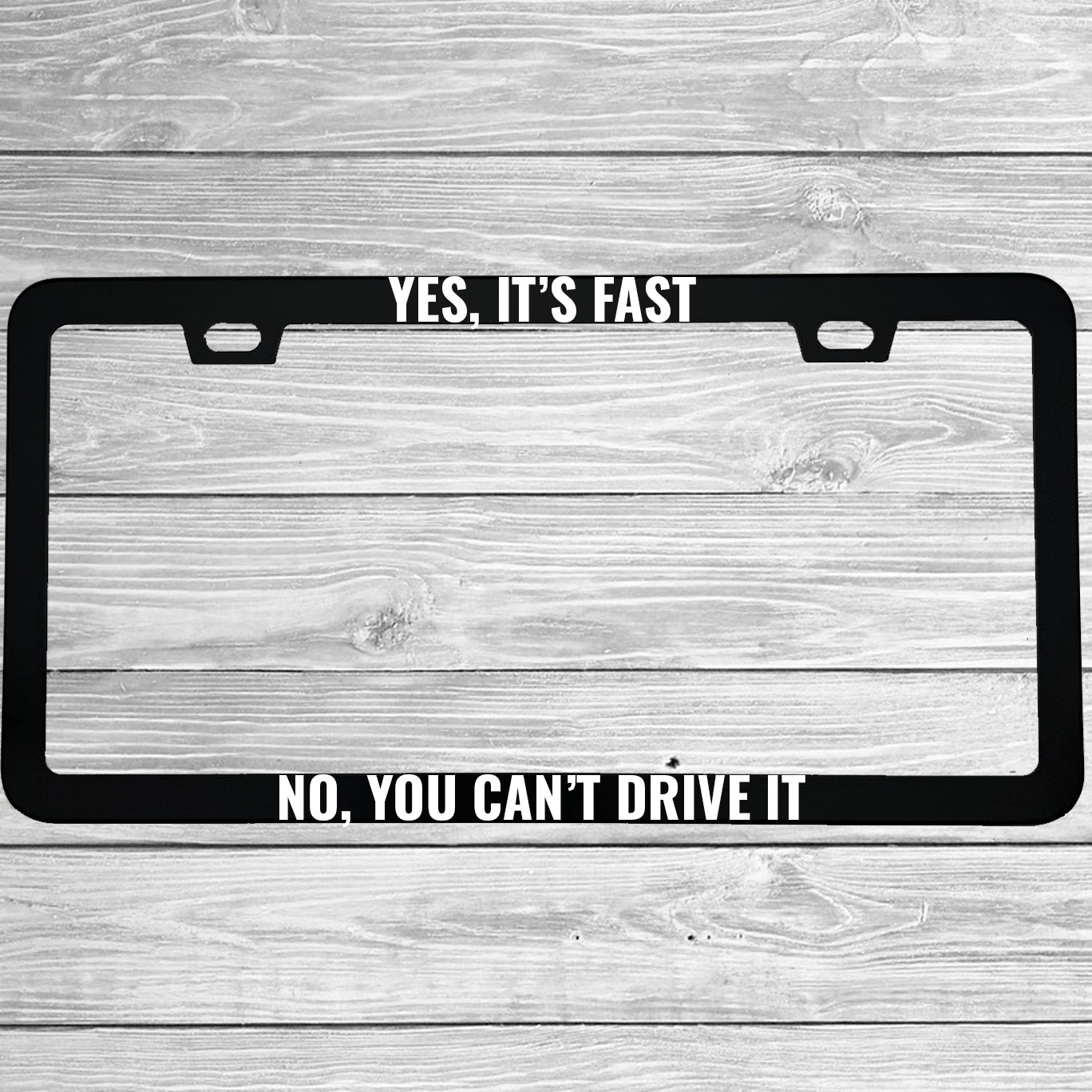 Close-up of "Yes Its Fast No You Cant Drive It" license plate frame showing fade-proof print quality