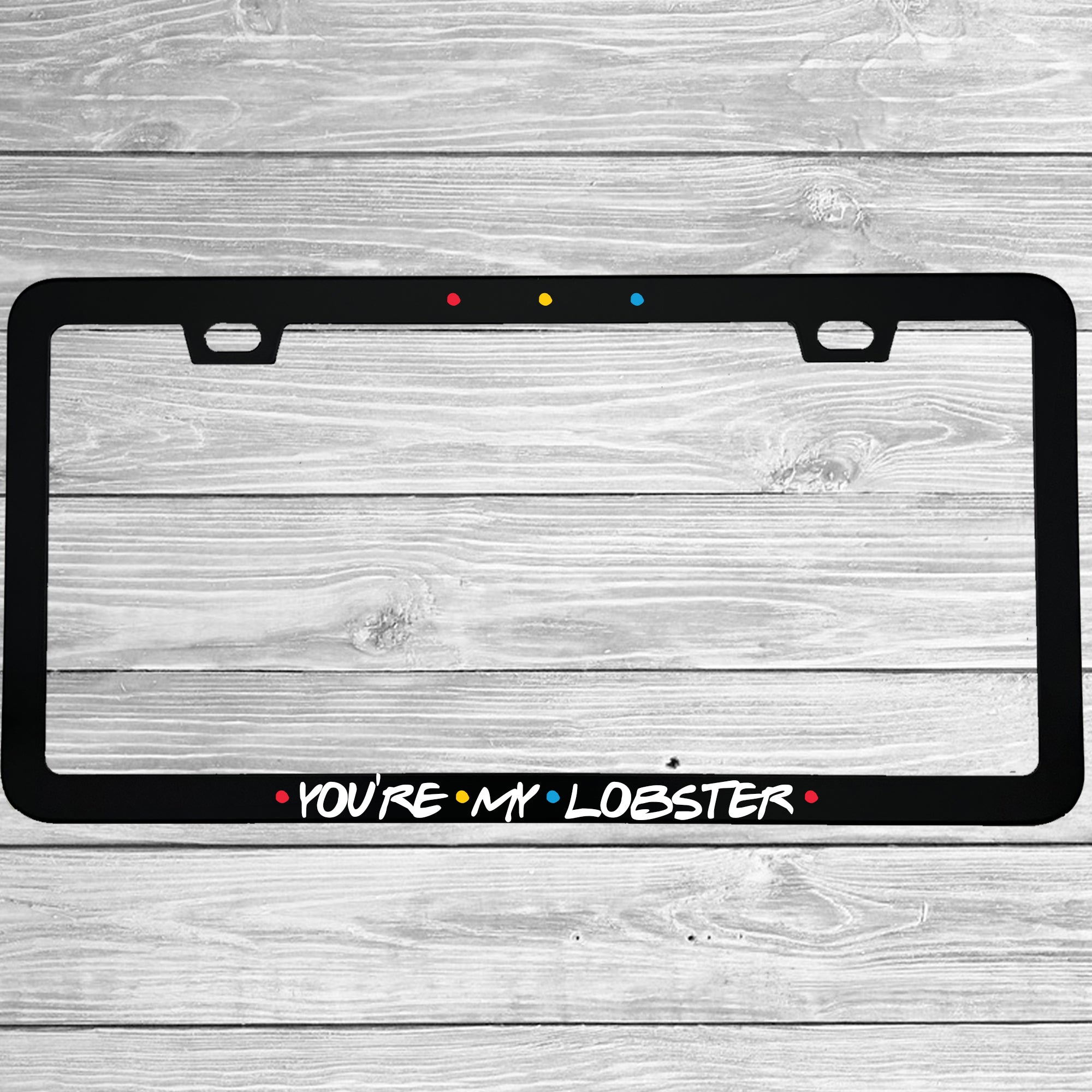 Close-up of "You're My Lobster" license plate frame showing fade-proof print quality