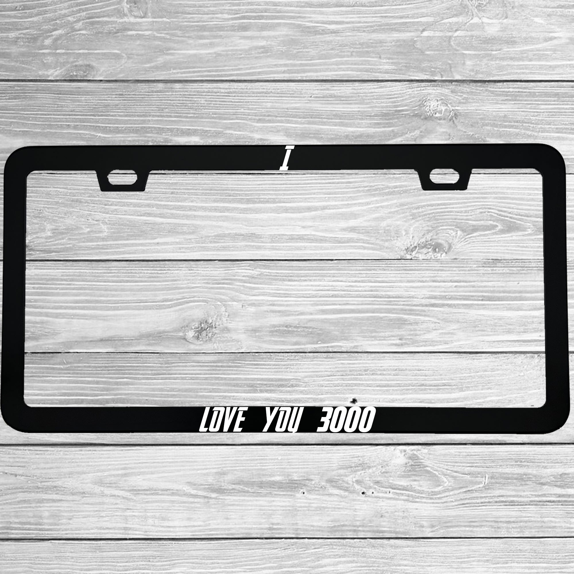 Close-up of "I Love You 3000" license plate frame showing fade-proof print quality