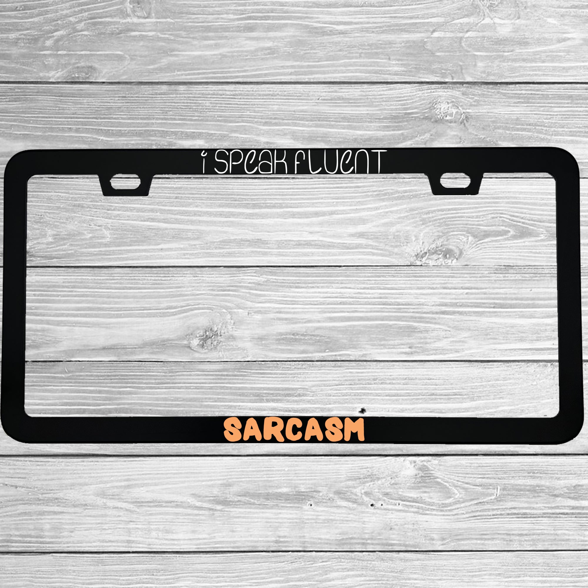 Close-up of "I Speak Fluent Sarcasm" license plate frame showing fade-proof print quality