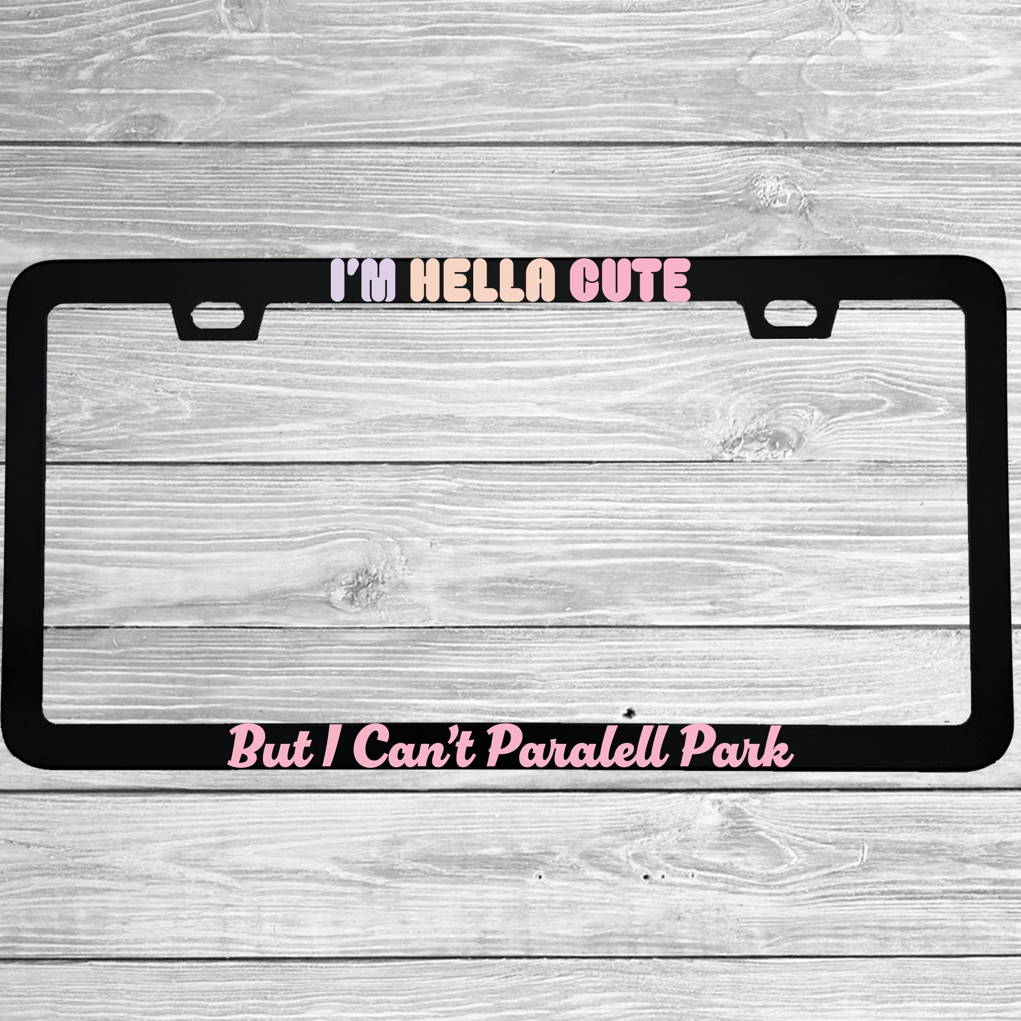 Close-up of "I'm Hella Cute But I Can't Parallel Park" license plate frame showing fade-proof print quality