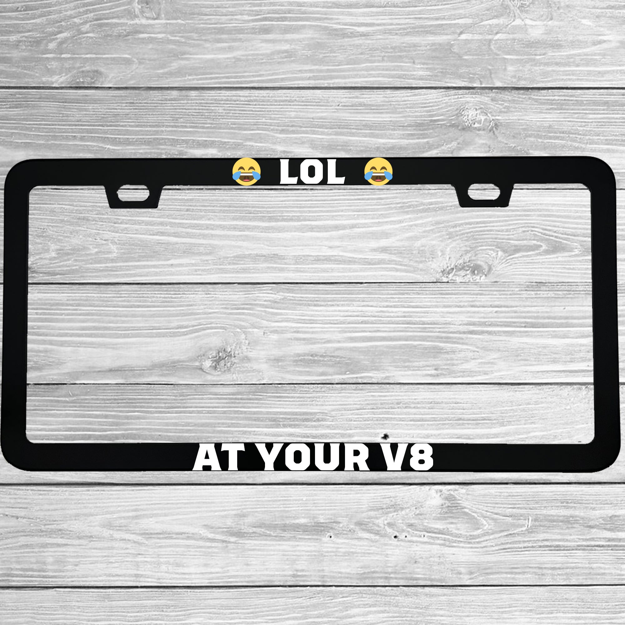 Close-up of "Lol At Your V8" license plate frame showing fade-proof print quality