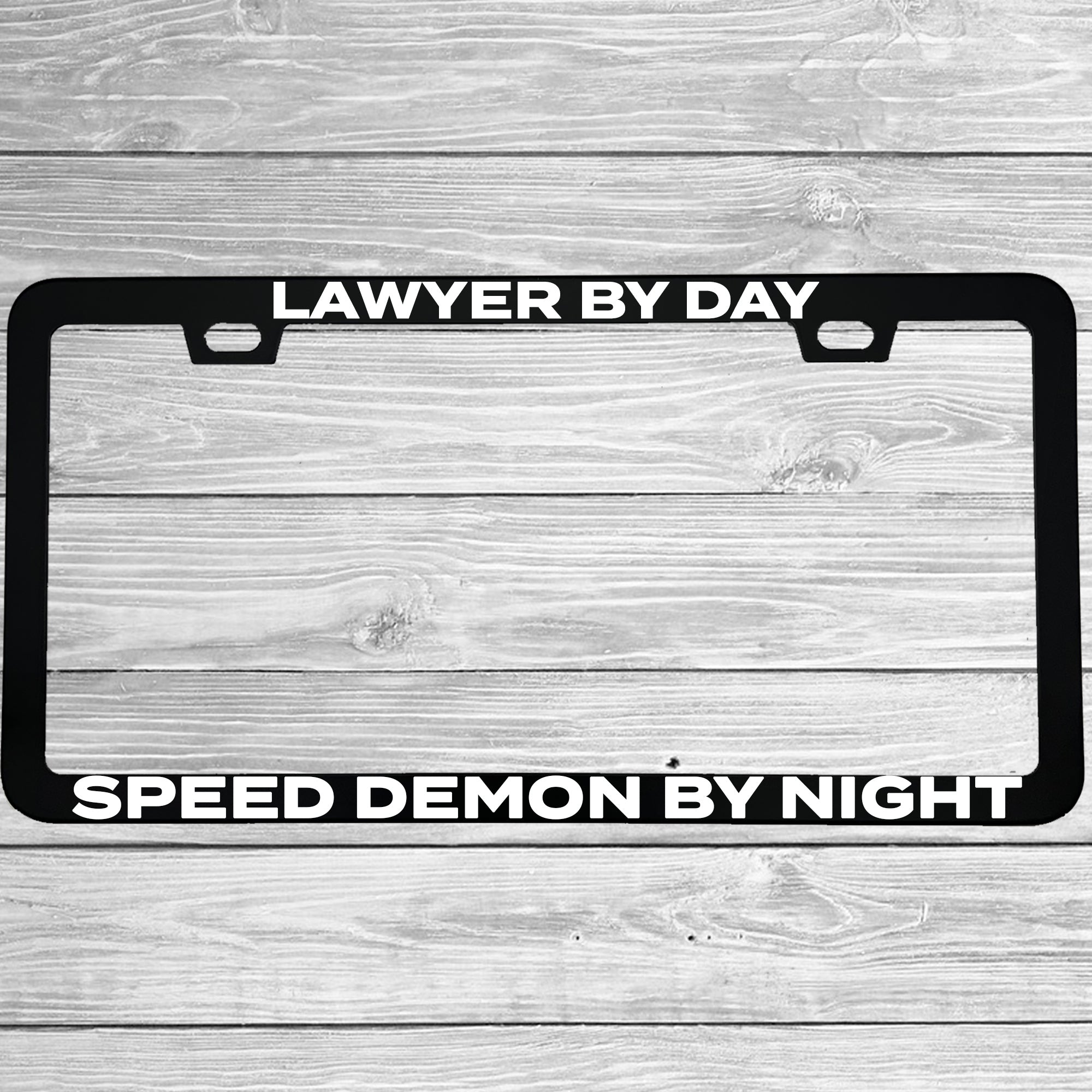 Close-up of "Lawyer By Day, Speed Demon By Night" license plate frame showing fade-proof print quality