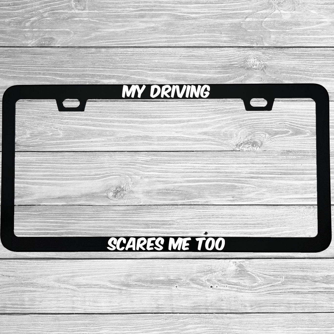 Close-up of "My Driving Scares Me Too" license plate frame showing fade-proof print quality