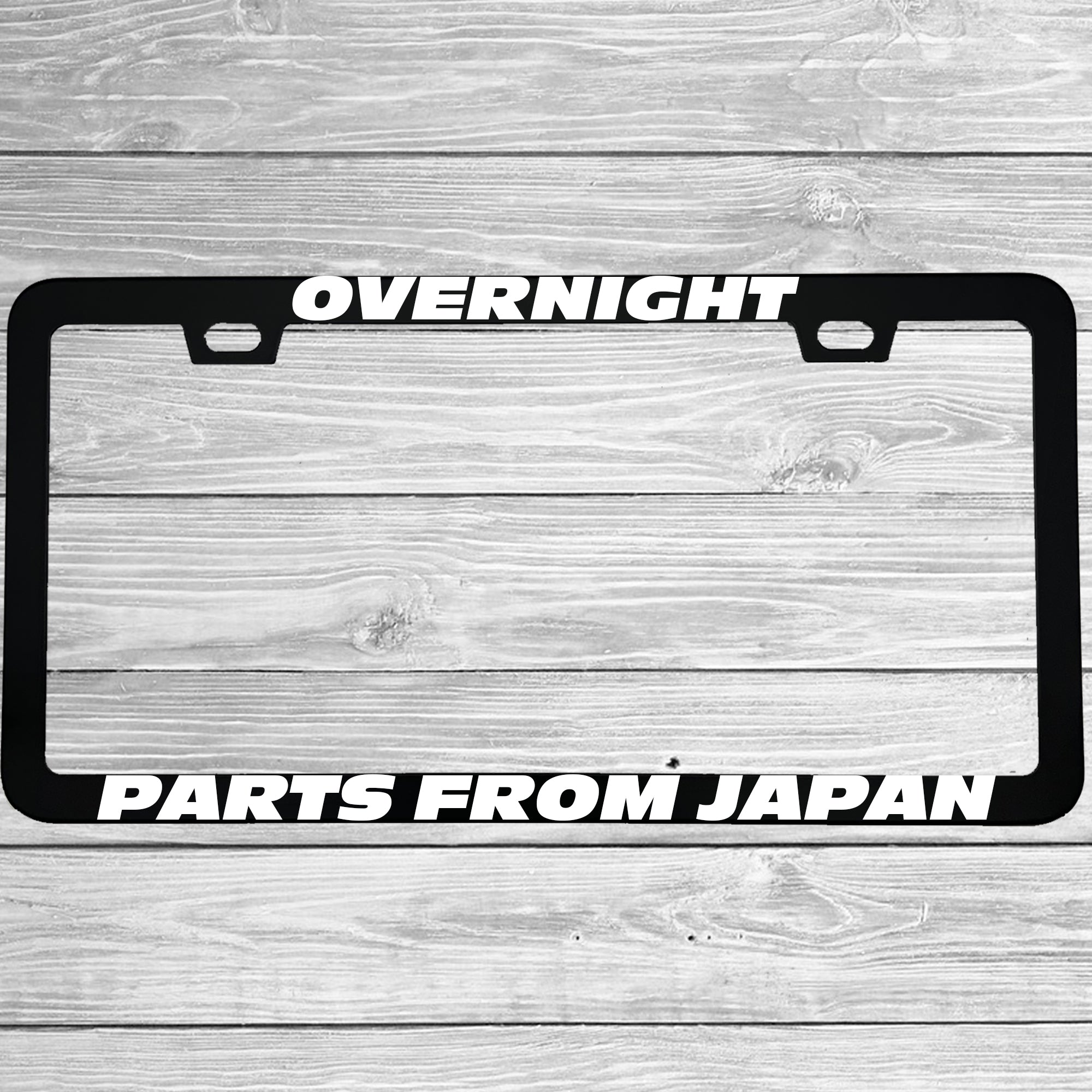 Close-up of "Overnight Parts From Japan" license plate frame showing fade-proof print quality
