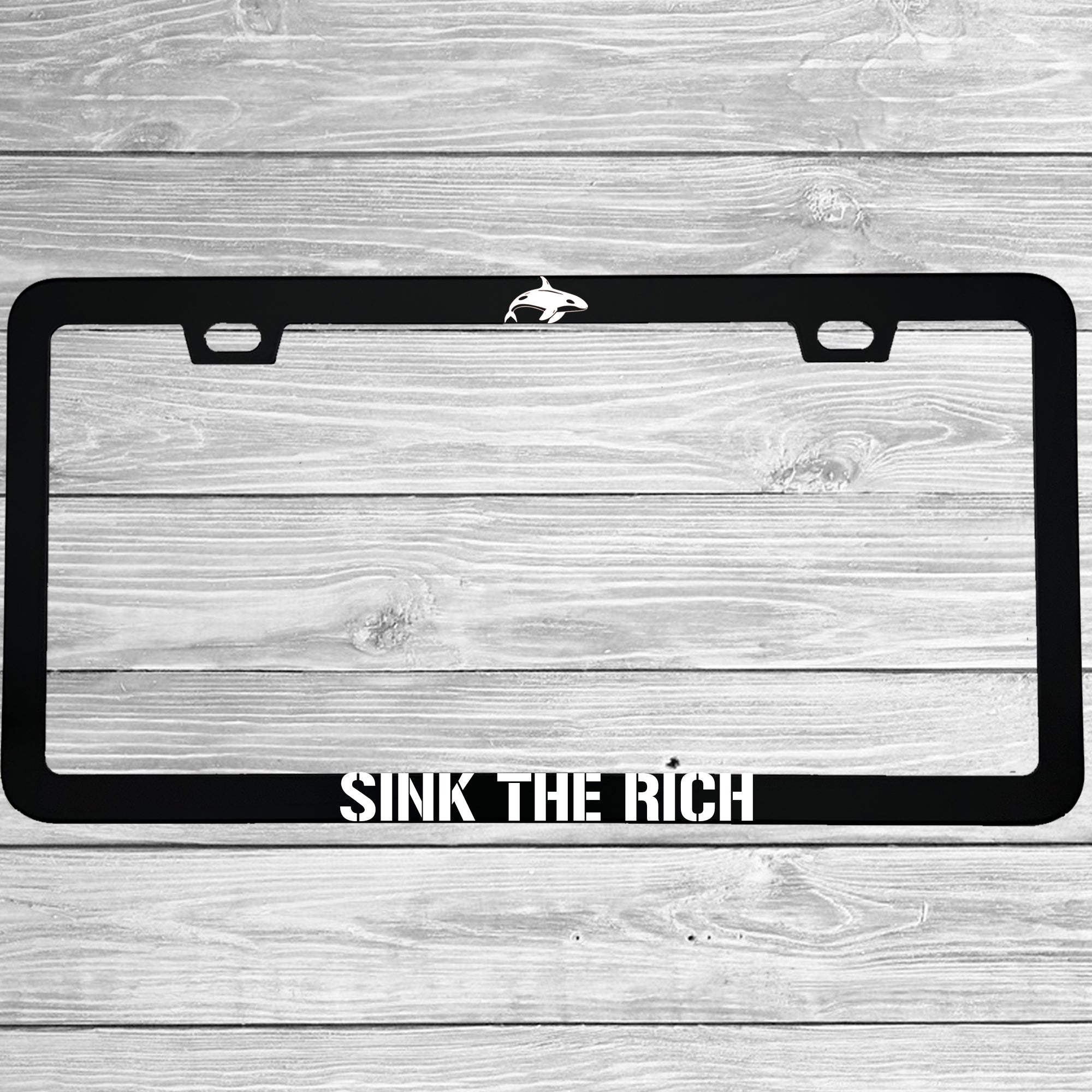 Close-up of "Sink The Rich" license plate frame showing fade-proof print quality