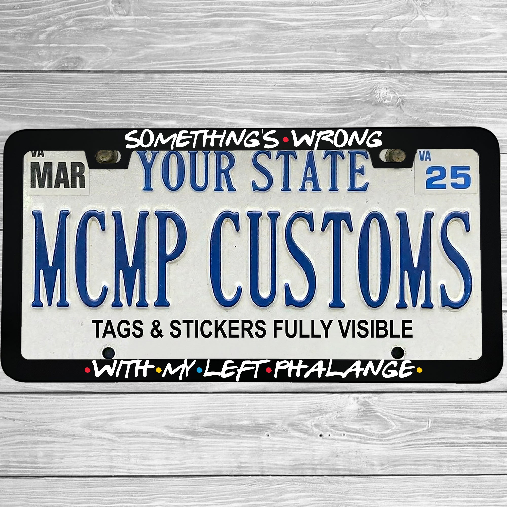 "Something's Wrong With My Left Phalange" license plate frame shown on vehicle — lifestyle photo
