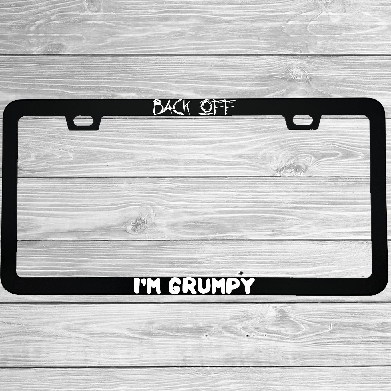 Close-up of "Back Off I'm Grumpy" license plate frame showing fade-proof print quality