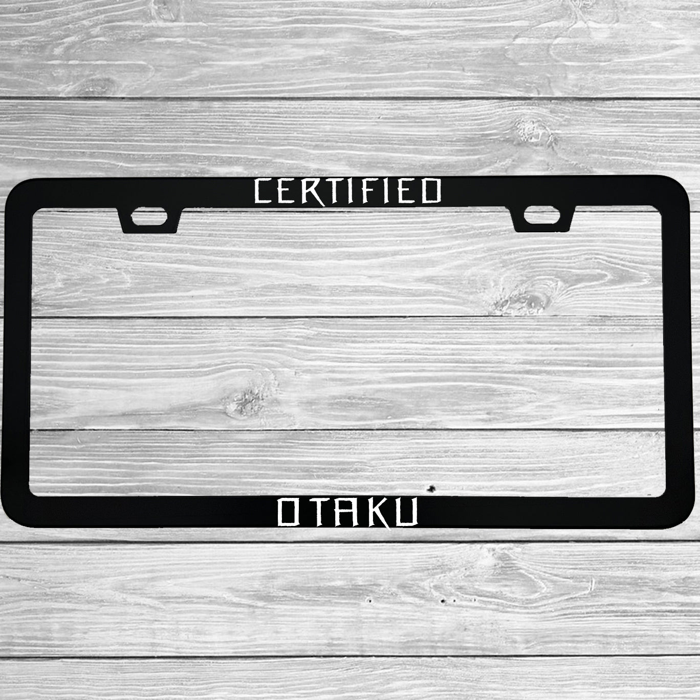 Close-up of "Certified Otaku" license plate frame showing fade-proof print quality