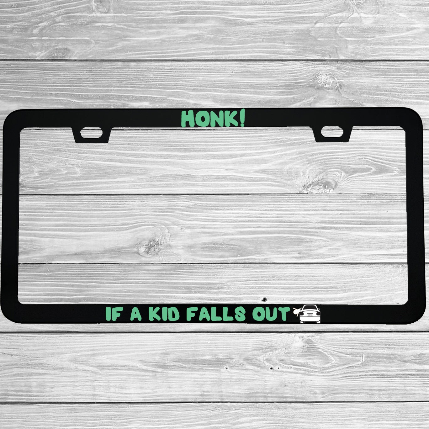Close-up of "Honk If A Kid Falls Out" license plate frame showing fade-proof print quality