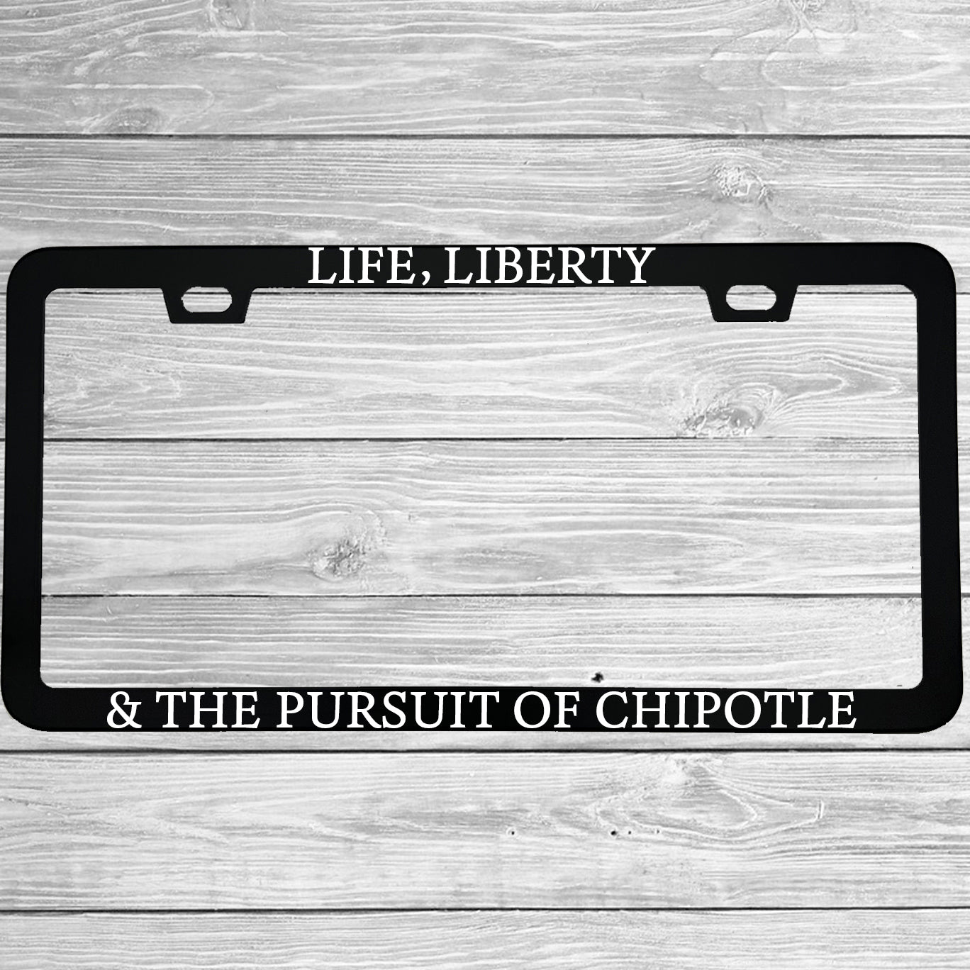 Close-up of "Life Liberty And The Pursuit Of Chipotle" license plate frame showing fade-proof print quality