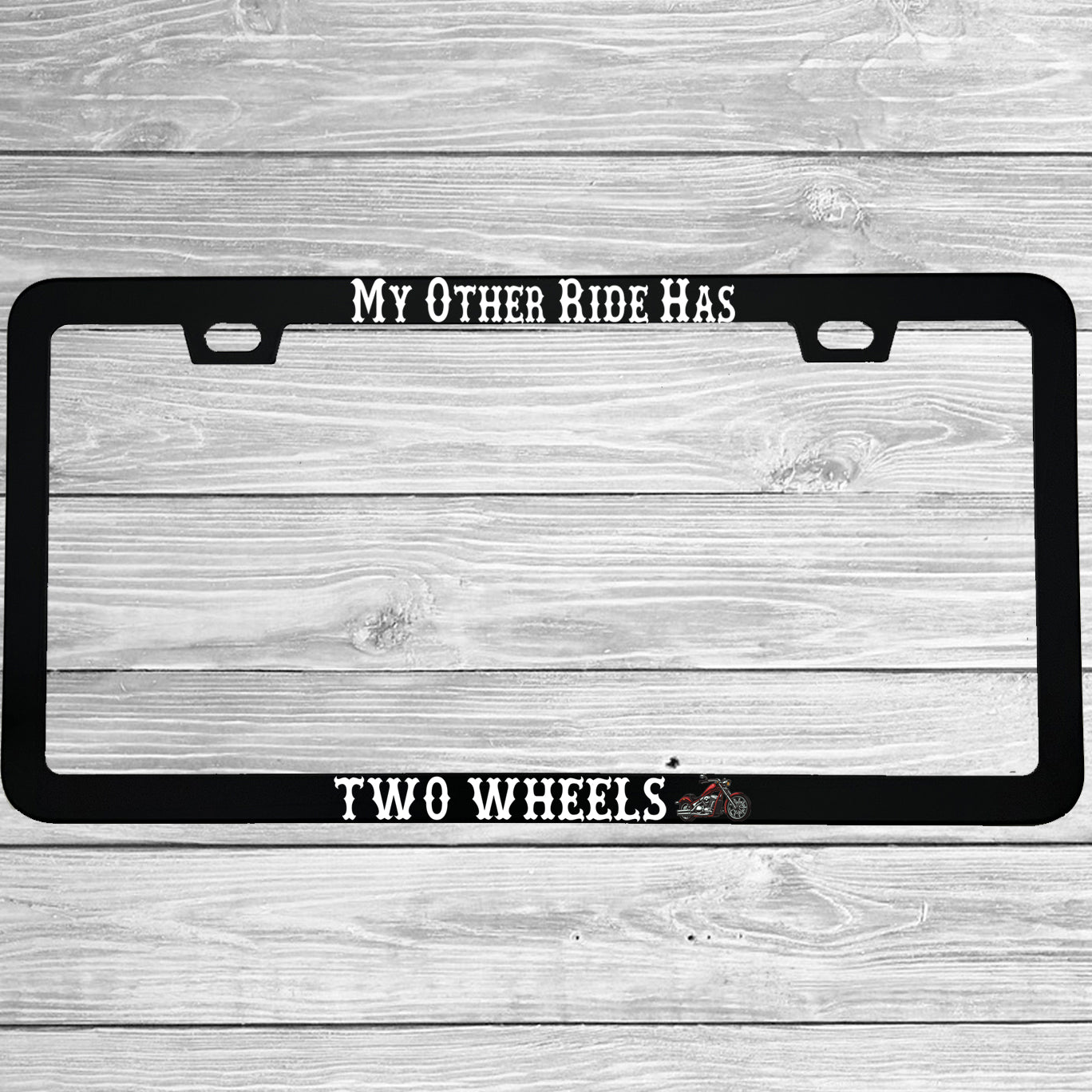 Close-up of "My Other Ride Has Two Wheels" license plate frame showing fade-proof print quality