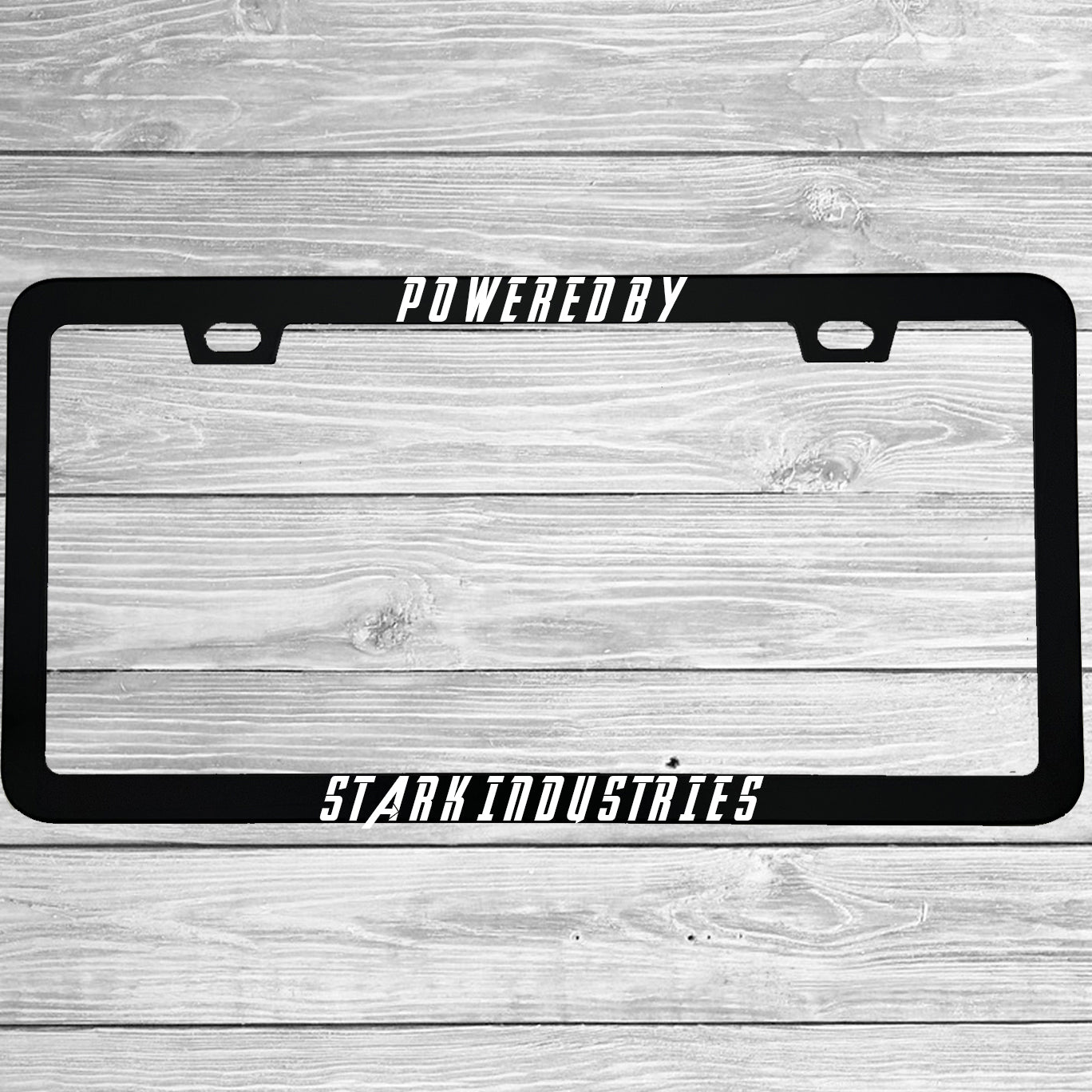 Close-up of "Powered By Stark Industries" license plate frame showing fade-proof print quality