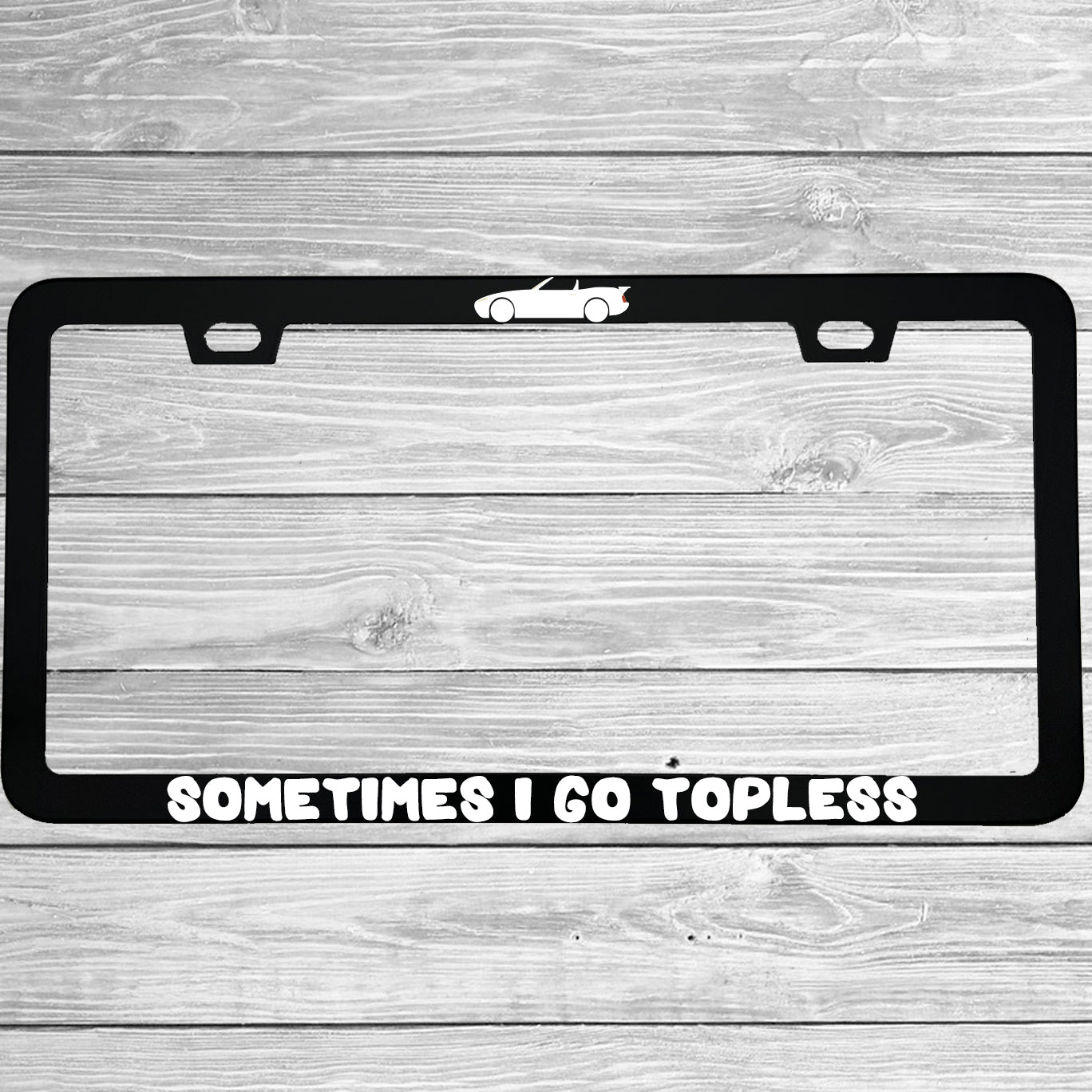 Close-up of "Sometimes I Go Topless" license plate frame showing fade-proof print quality