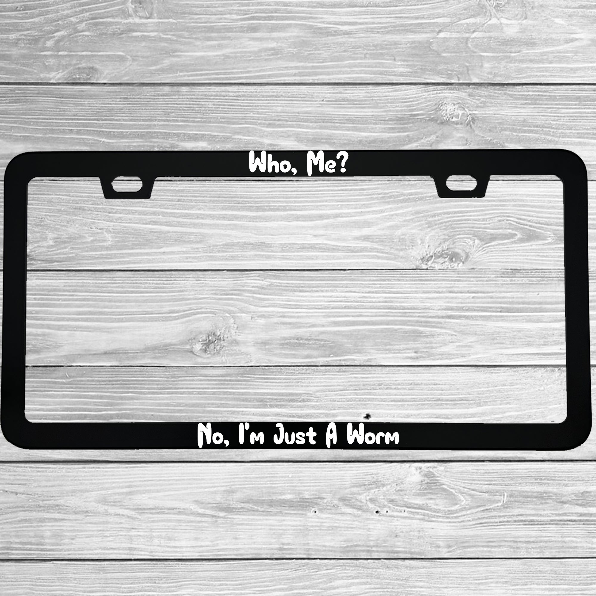 Close-up of "Who, Me?  No, I'm Just A Worm" license plate frame showing fade-proof print quality
